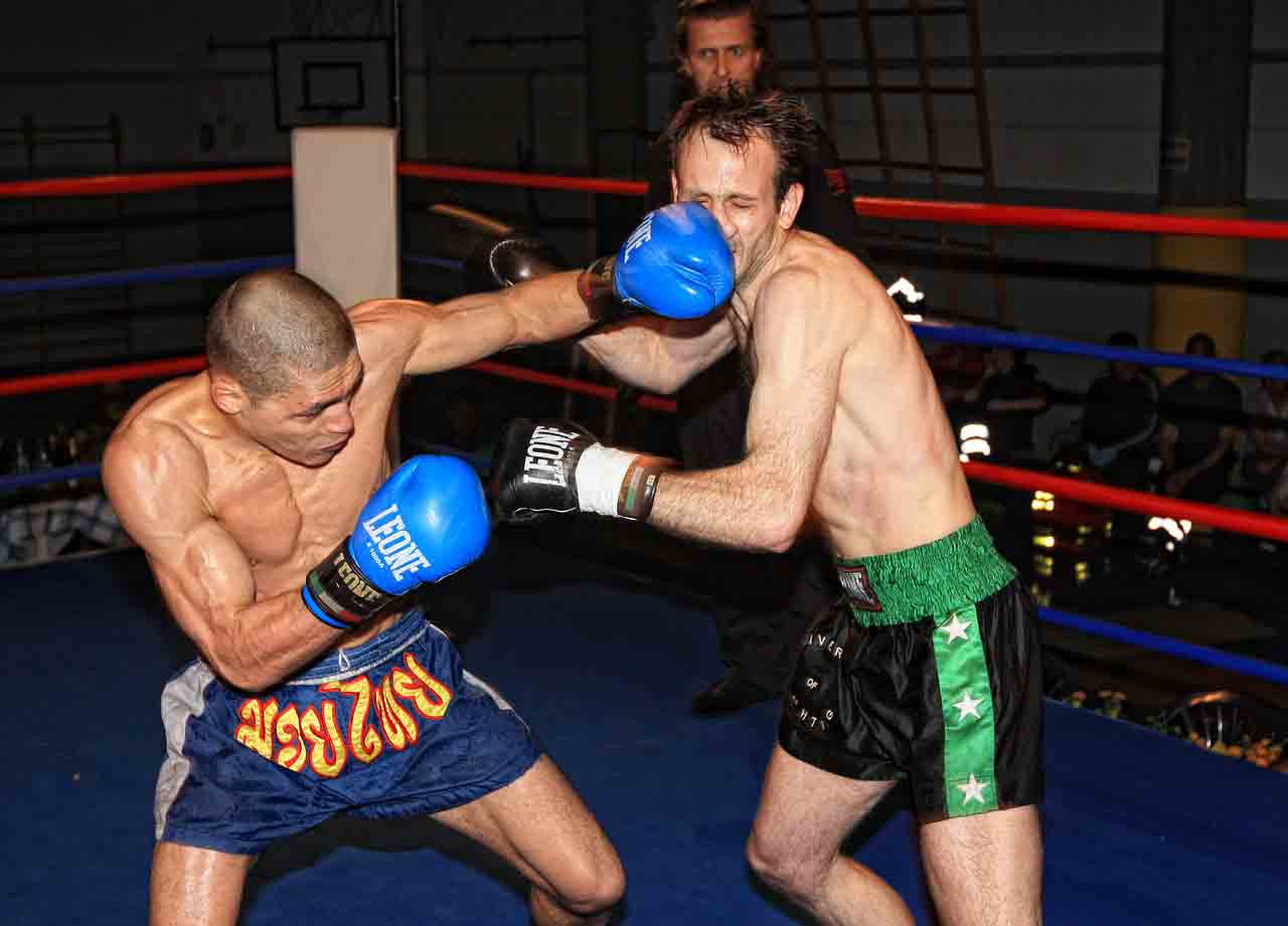 Guy getting punched in the face in a boxing ring